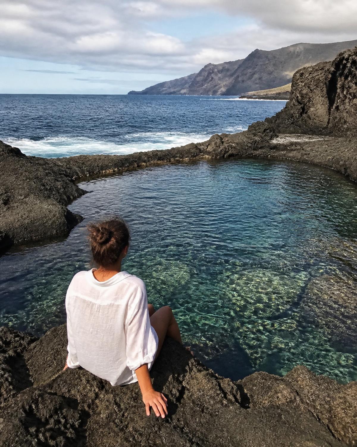 Clear natural sea pool surrounded by dark volcanic rock on the Tenerife coast