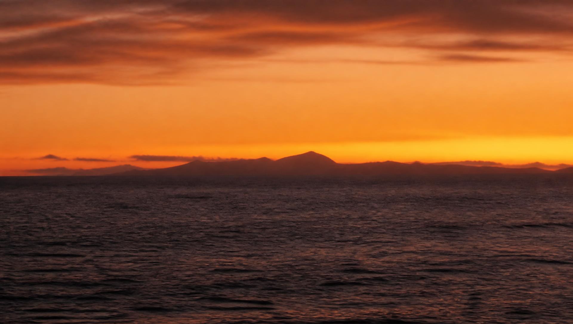 Atlantic sunset seen from the south west coast of Tenerife with La Gomera on the horizon